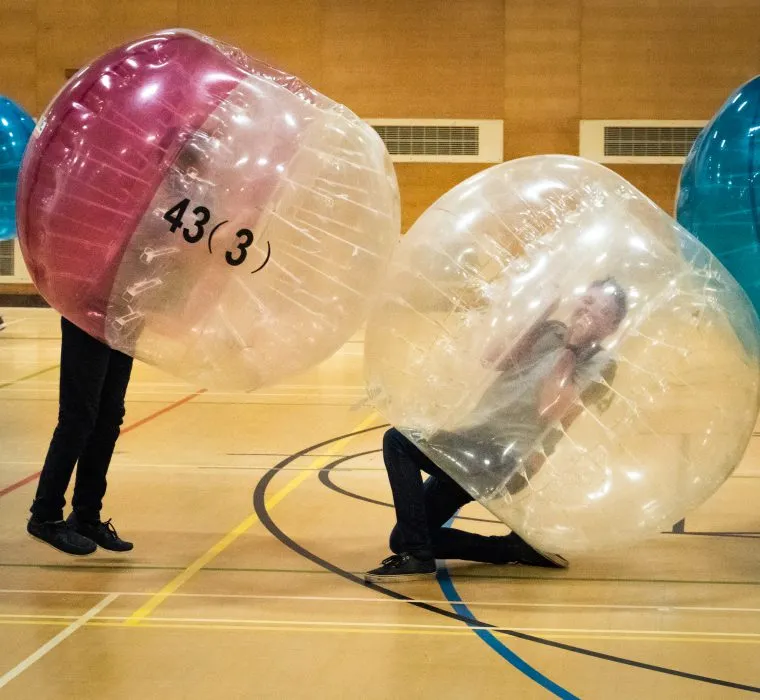 Indoor Zorb Football person jumping and knocking over another player